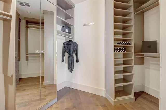 walk in closet with hardwood / wood-style flooring