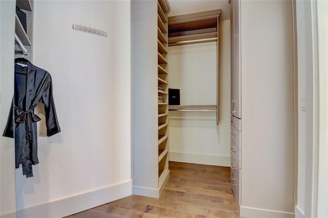 walk in closet with light hardwood / wood-style floors