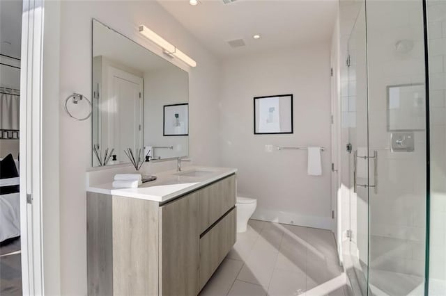 bathroom featuring tile patterned flooring, vanity, toilet, and a shower with door