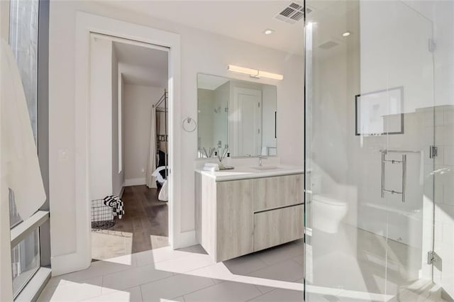 bathroom with hardwood / wood-style flooring, vanity, toilet, and walk in shower