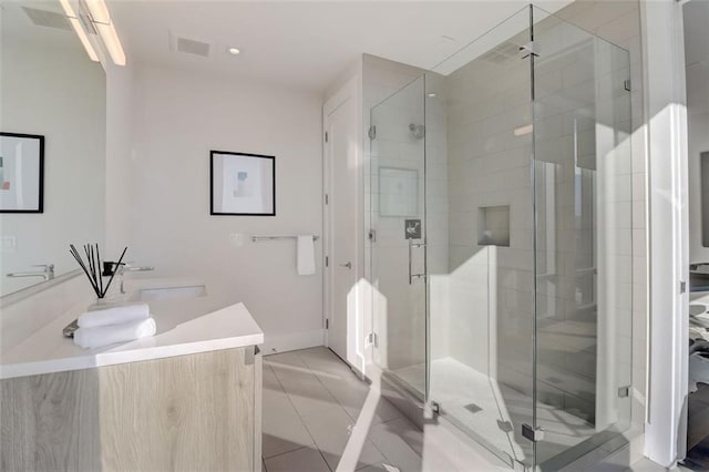 bathroom with tile patterned flooring, an enclosed shower, and vanity