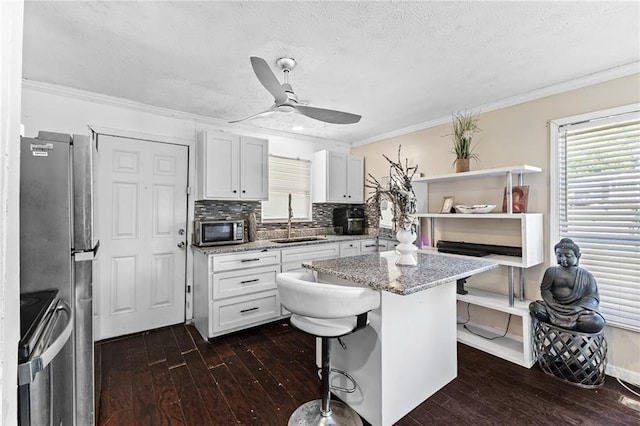 2446 Martin Luther King Jr Blvd, Gainesville, GA 30501 - kitchen with stainless steel appliances, dark wood finished floors, a ceiling fan, a textured ceiling, and white cabinets