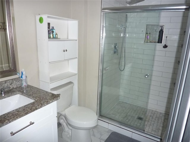 bathroom featuring toilet, a stall shower, marble finish floor, and vanity