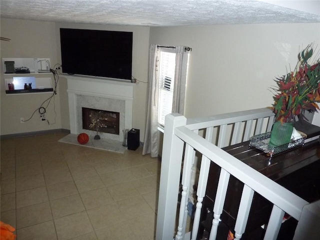 tiled living room featuring a fireplace and a textured ceiling