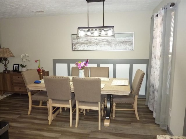 dining room featuring a textured ceiling and wood finished floors