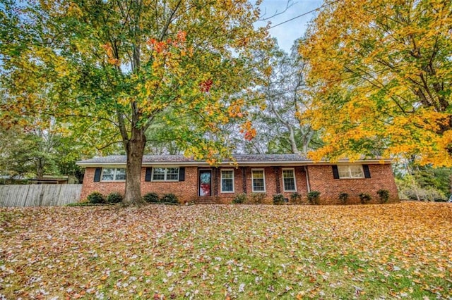 ranch-style home with brick siding and fence