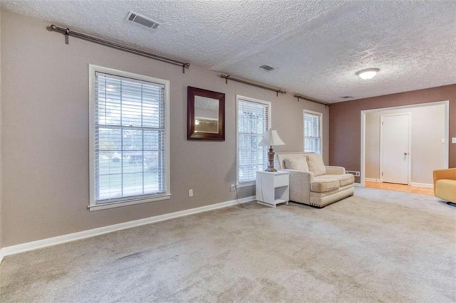 unfurnished room featuring visible vents, light carpet, and baseboards