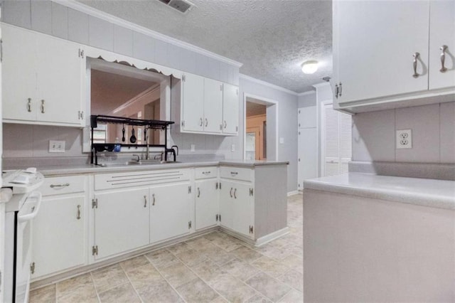 kitchen featuring visible vents, white cabinets, ornamental molding, light countertops, and a textured ceiling