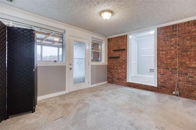 interior space featuring a textured ceiling, brick wall, visible vents, and crown molding