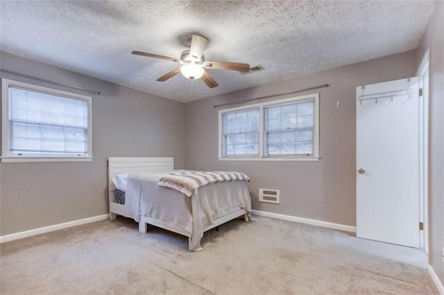 bedroom with multiple windows, light colored carpet, and baseboards