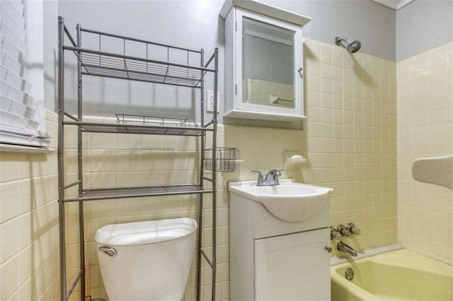 full bath featuring toilet, shower / bathing tub combination, vanity, and tile walls