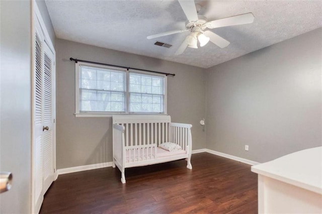 unfurnished bedroom with visible vents, a textured ceiling, baseboards, and wood finished floors