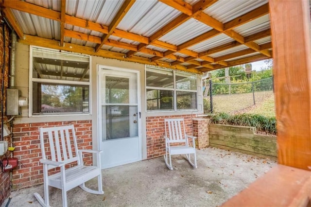 property entrance featuring fence and brick siding