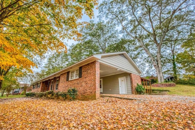 view of side of property with a carport and brick siding