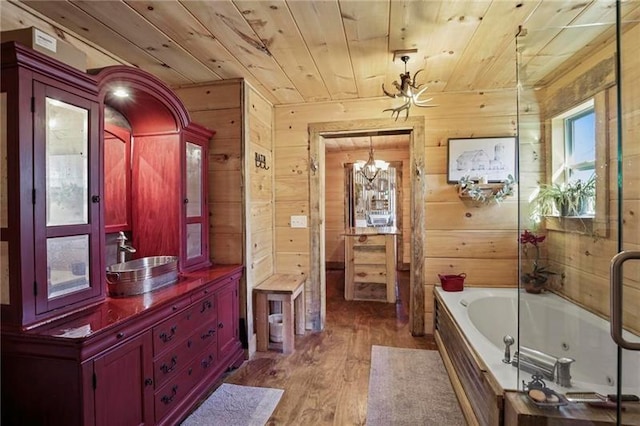 bathroom featuring hardwood / wood-style floors, a tub, wood ceiling, a notable chandelier, and wood walls