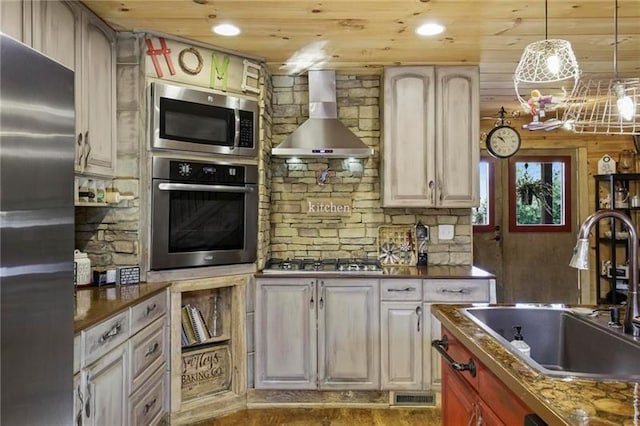 kitchen featuring hardwood / wood-style flooring, wall chimney exhaust hood, wood ceiling, appliances with stainless steel finishes, and sink