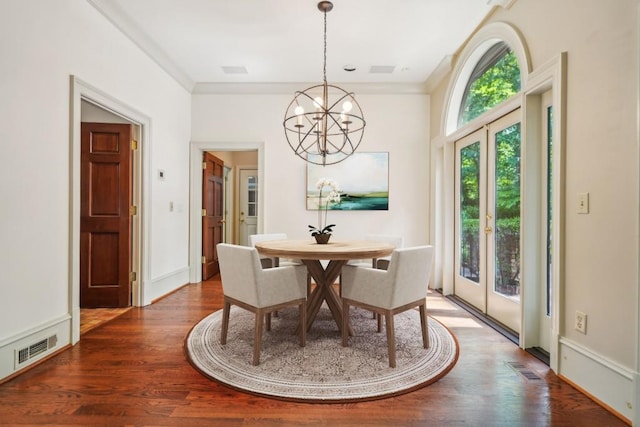 dining room featuring a chandelier, wood finished floors, french doors, crown molding, and baseboards