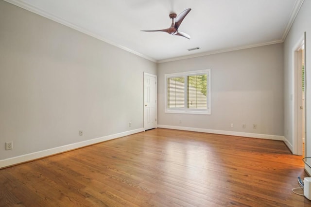 spare room featuring wood finished floors, crown molding, baseboards, and ceiling fan