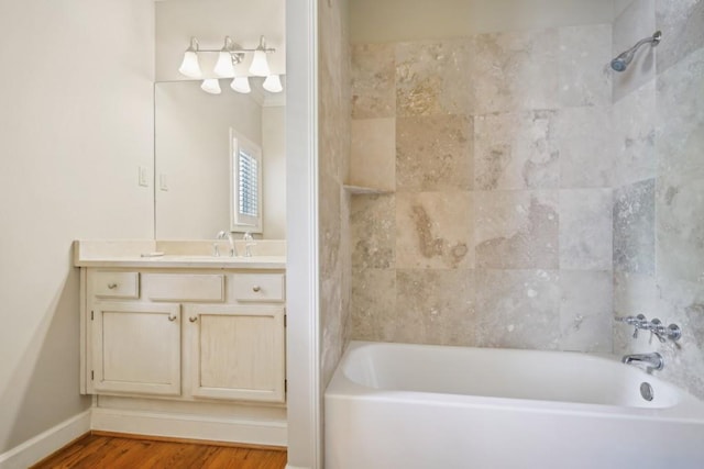 full bathroom featuring wood finished floors, vanity, shower / washtub combination, and baseboards