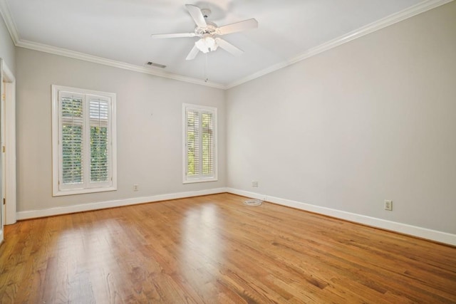 spare room featuring healthy amount of natural light, baseboards, light wood-type flooring, crown molding, and ceiling fan