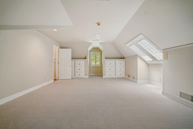 additional living space featuring vaulted ceiling, light carpet, baseboards, and recessed lighting