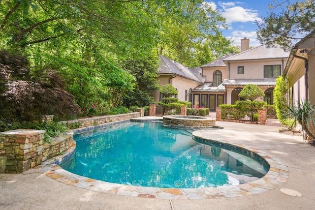 view of swimming pool featuring a patio area and a pool with connected hot tub