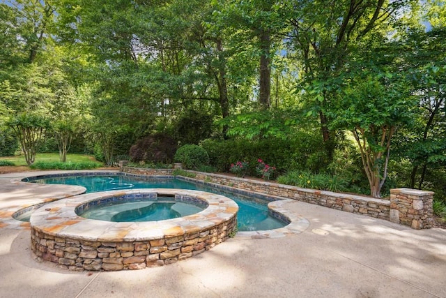 view of pool featuring a patio area and a pool with connected hot tub