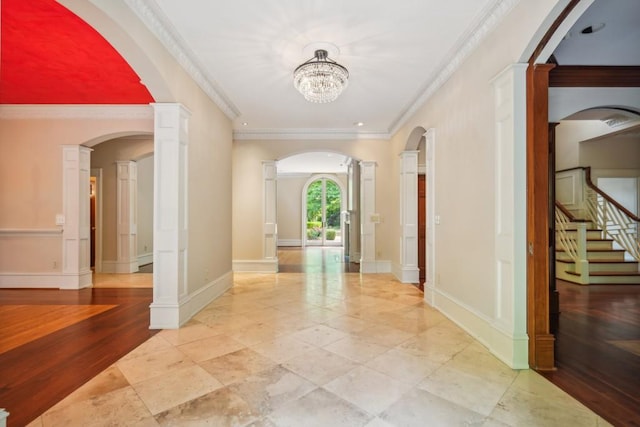 entrance foyer with crown molding, stairway, baseboards, and a chandelier