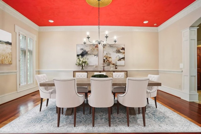 dining area with a chandelier, wood finished floors, ornamental molding, recessed lighting, and baseboards