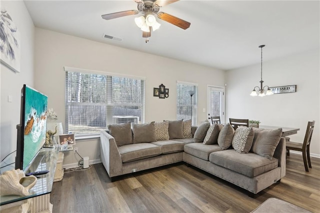 living room featuring dark hardwood / wood-style floors and ceiling fan with notable chandelier