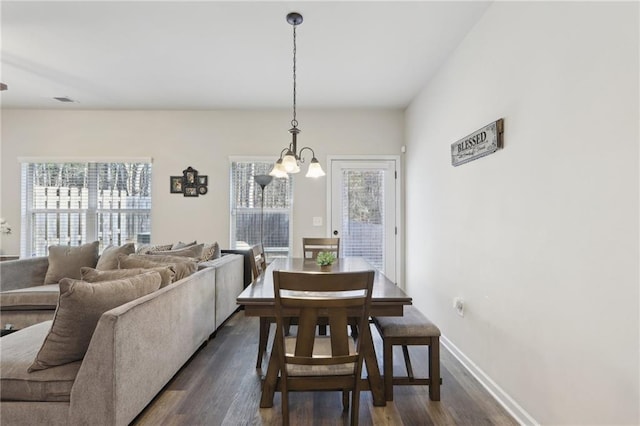 dining room featuring dark hardwood / wood-style floors, a wealth of natural light, and a notable chandelier