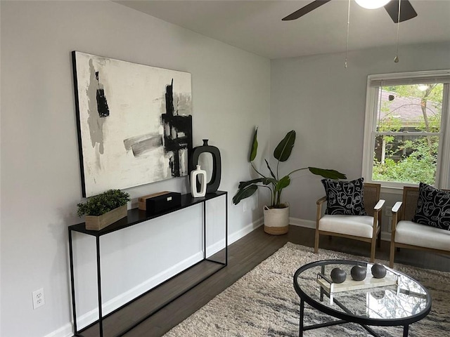 living area featuring dark hardwood / wood-style floors and ceiling fan