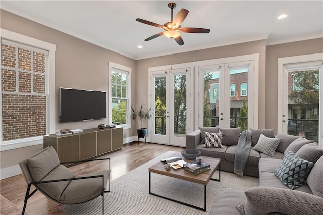 living room featuring ceiling fan, crown molding, light hardwood / wood-style flooring, and french doors