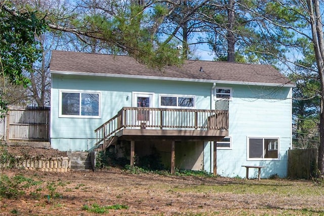 rear view of house with stairs, a deck, and fence