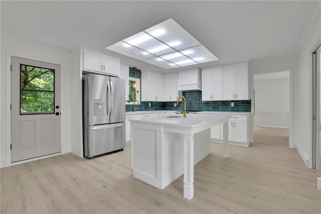 4717 Westhampton Dr, Tucker, GA 30084 - kitchen with stainless steel refrigerator with ice dispenser, custom exhaust hood, a sink, tasteful backsplash, and light wood-style flooring