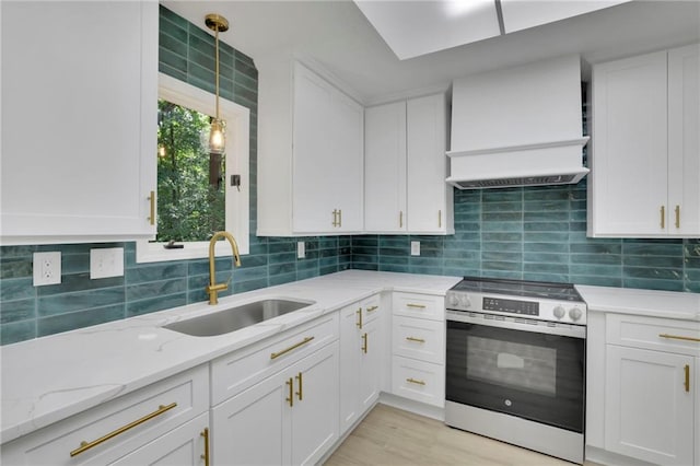 4717 Westhampton Dr, Tucker, GA 30084 - kitchen with stainless steel range with electric stovetop, a sink, premium range hood, white cabinets, and decorative backsplash