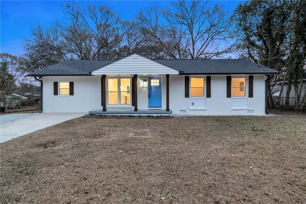 ranch-style house with covered porch and a front yard