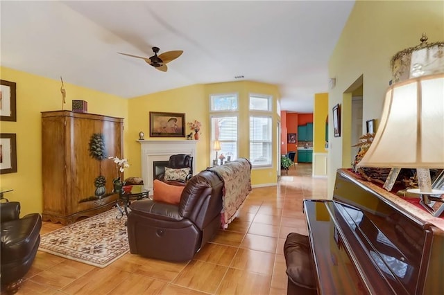 living room featuring ceiling fan, vaulted ceiling, and light tile patterned floors