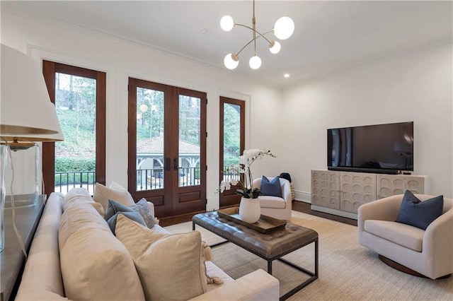 living room with baseboards, ornamental molding, a chandelier, and french doors