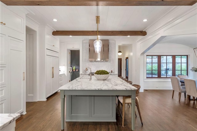 kitchen with dark wood-style floors, light stone counters, beamed ceiling, and a sink