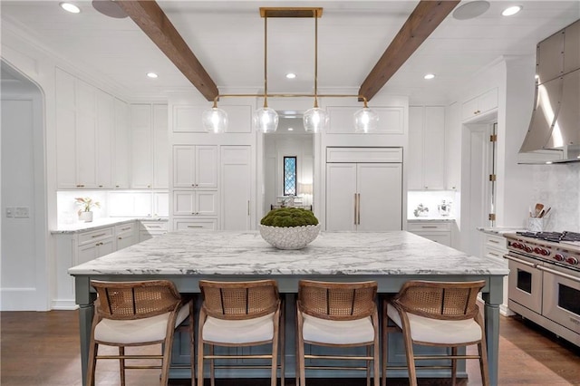 kitchen featuring high end appliances, dark wood-type flooring, white cabinetry, light stone countertops, and a kitchen breakfast bar