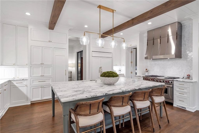 kitchen featuring dark wood-style flooring, high end appliances, decorative backsplash, white cabinetry, and wall chimney exhaust hood