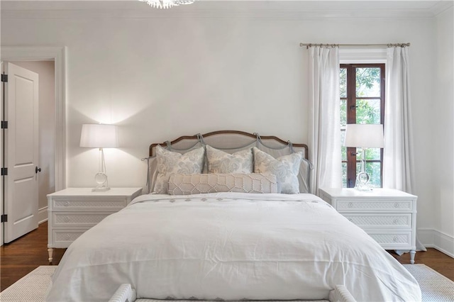 bedroom featuring ornamental molding, dark wood-type flooring, and baseboards