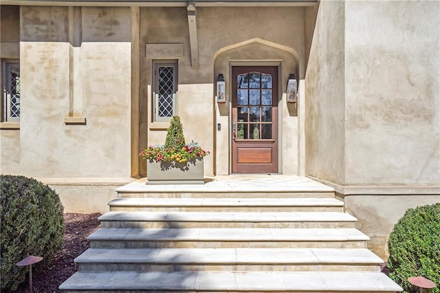 entrance to property featuring stucco siding