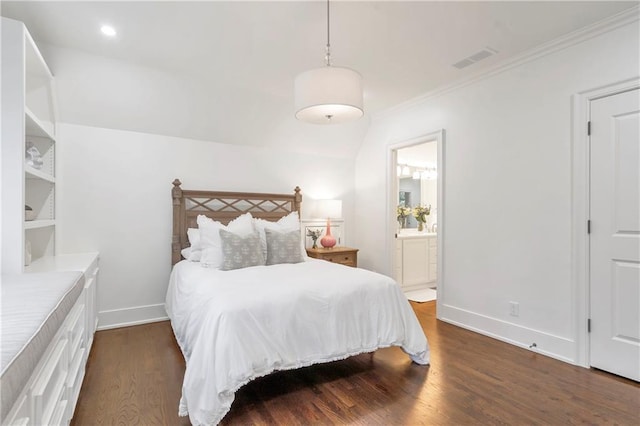 bedroom featuring dark wood-style flooring, visible vents, ornamental molding, connected bathroom, and baseboards