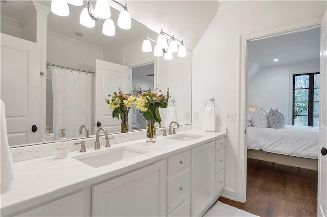 full bathroom featuring crown molding, wood finished floors, a sink, and an inviting chandelier