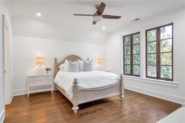 bedroom featuring lofted ceiling, wood finished floors, visible vents, and baseboards