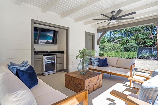 exterior space featuring a ceiling fan, wine cooler, fence, exterior kitchen, and outdoor lounge area