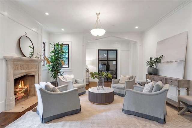 living room with a fireplace with flush hearth, recessed lighting, and crown molding