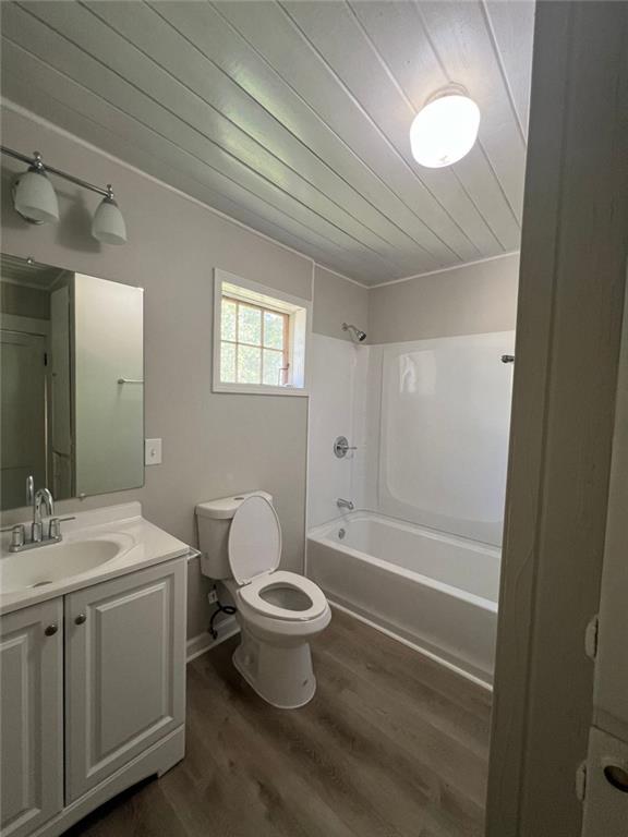 full bathroom with wood-type flooring, toilet, vanity, wood ceiling, and bathtub / shower combination